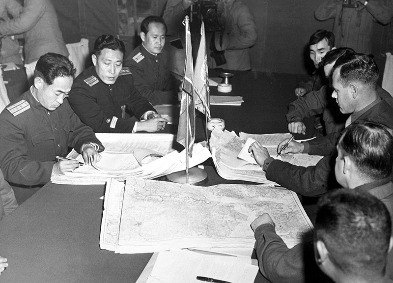 officials signing documents at table