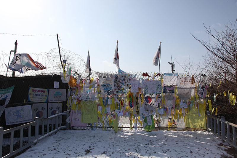 fence with razorwire and flags