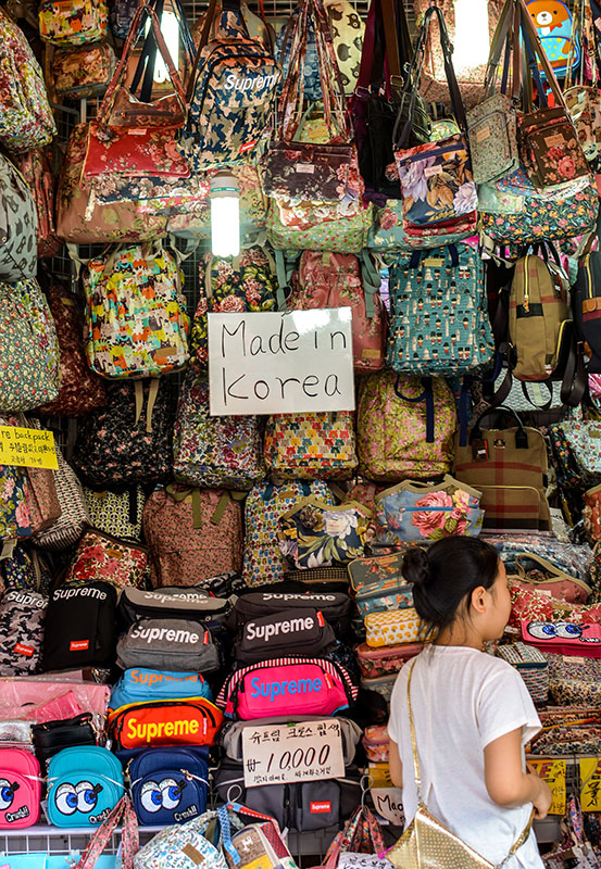 stall with handbags for sale - sign saying Made in Korea