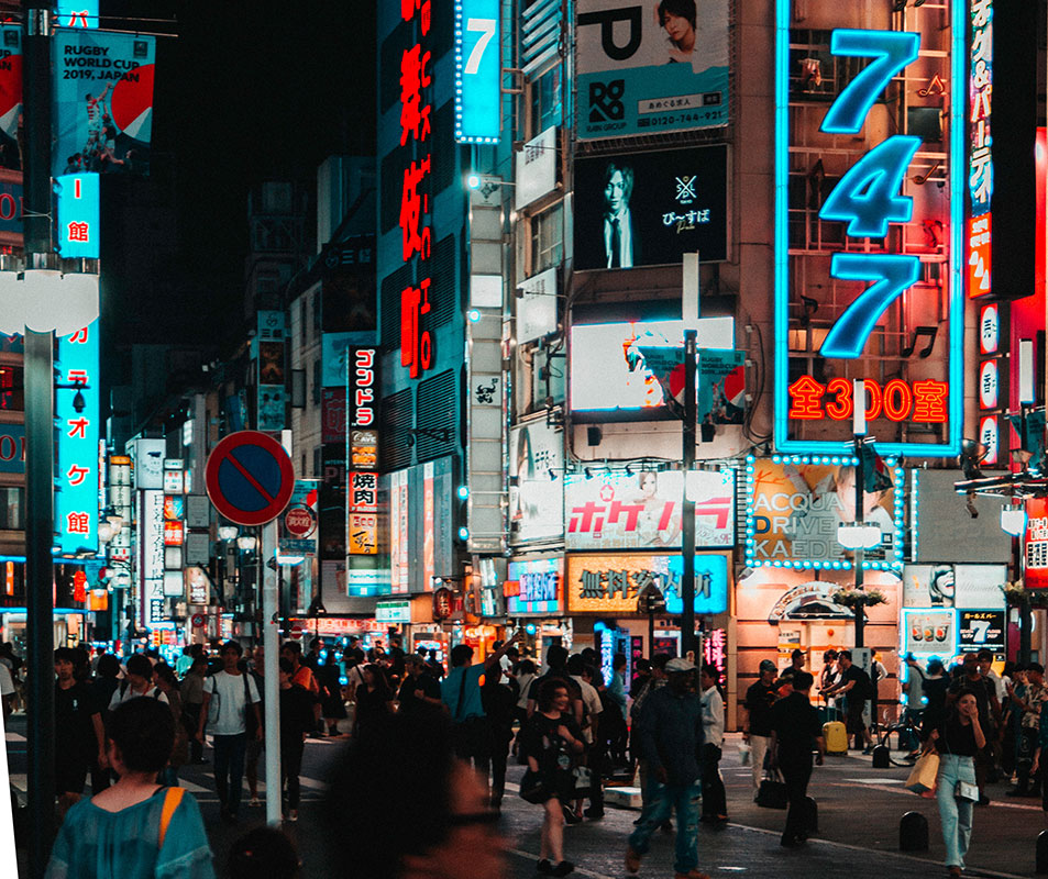 street scene at night with crowd and neon signs