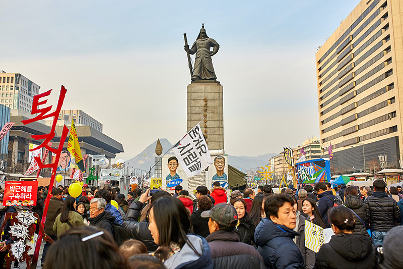 people with flags and banners in city square